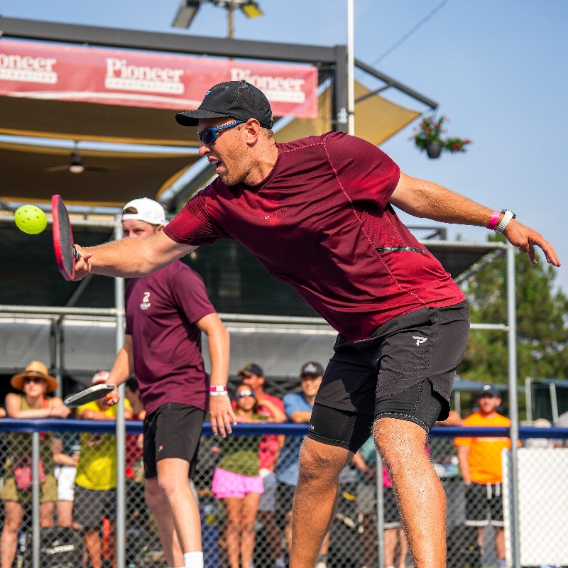 Jaron reaching for a pickleball during a tournament